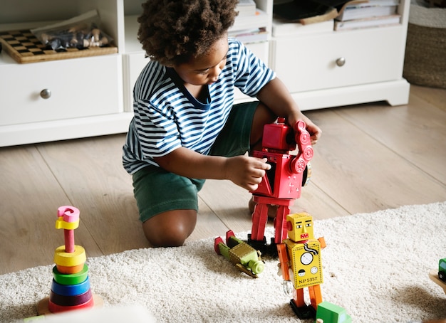 Niño negro jugando robot en casa