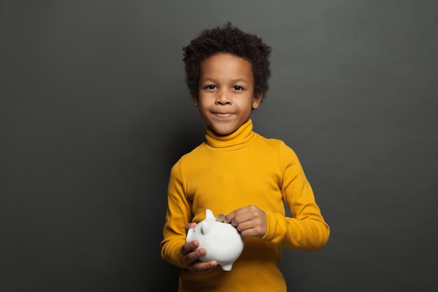 Niño negro listo con caja de dinero y moneda