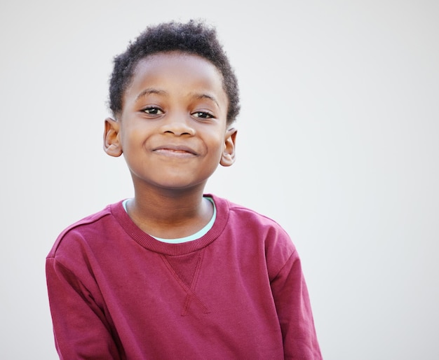 Niño negro o retrato con sonrisa en el estudio para el bienestar alegre para la ropa en Nueva York Niño felicidad o confianza en fondo blanco para la mentalidad positiva o la moda de invierno alegría o espacio