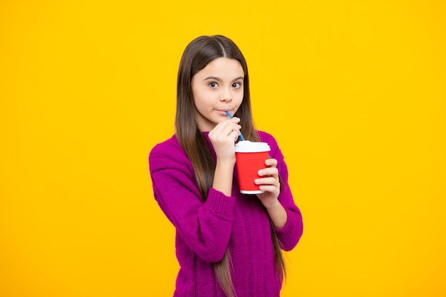 Niño niña 12 13 14 años con una taza para llevar de café capuchino o té Niño con una taza para llevar sobre fondo amarillo bebida por la mañana