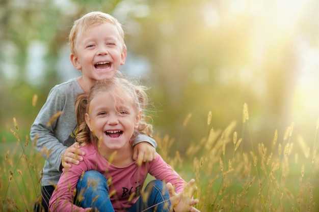 un niño y una niña abrazándose ahora riéndose mirando a la cámara y