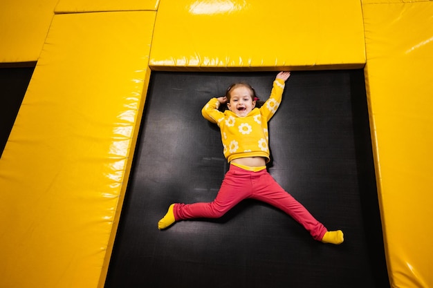 Niño niña acostado en un trampolín en el parque infantil