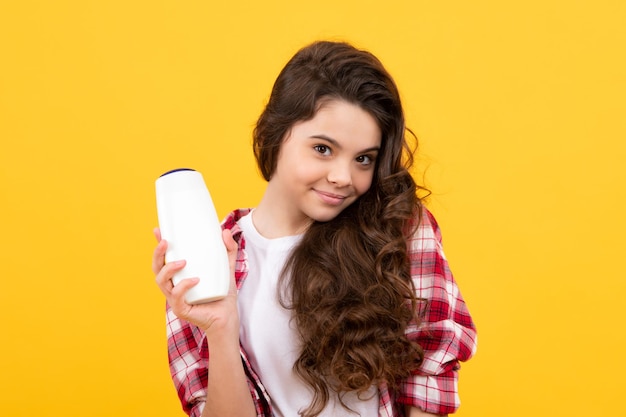 Niño niña adolescente con acondicionadores de champús y gel de ducha Cuidado del cabello largo de adolescente Presentación de producto cosmético botella de champú Adolescente feliz emociones positivas y sonrientes de niña adolescente