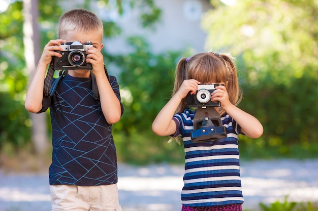 Niño y niña aprendiendo a usar la cámara de fotos