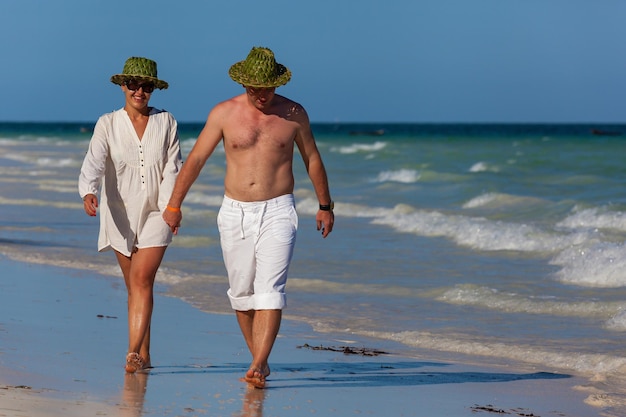 Niño y niña caminando por la playa