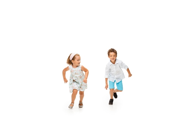 Niño y niña corriendo sobre fondo blanco.