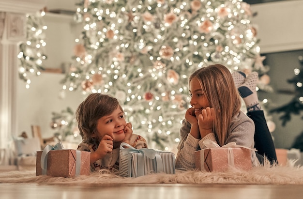 El niño y la niña decoran un árbol de navidad.