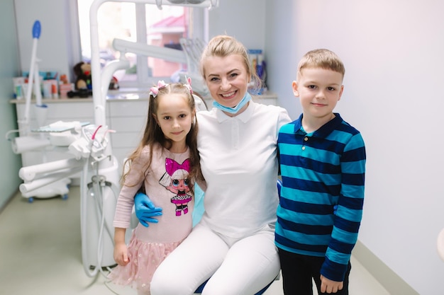 Niño y niña con dentista en clínica Niños felices