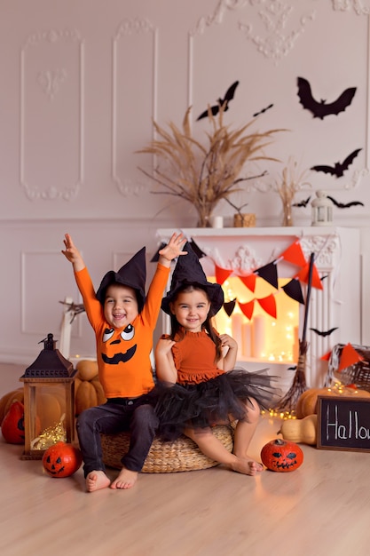 Foto niño y niña disfrazados de bruja de halloween