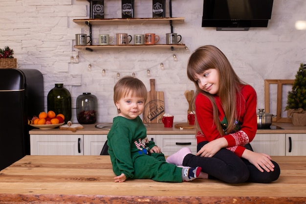 Niño y niña se divierten en la cocina de casa