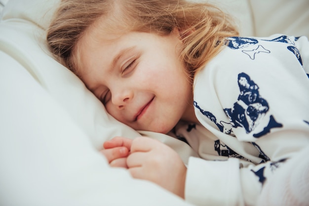 Niño niña duerme en la cama