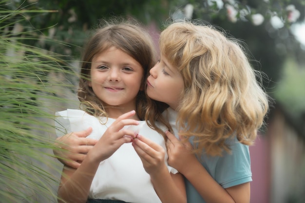 Niño y niña enamorados niños alegres jugando en el parque al aire libre retrato de verano de chi lindo feliz