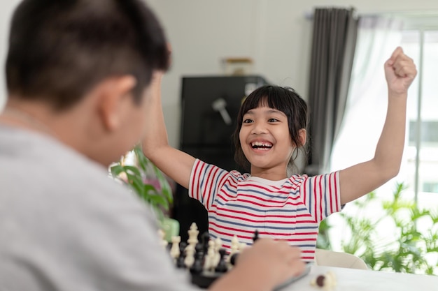 Niño y niña están jugando al ajedrez en casaNiños jugando al ajedrez