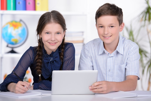 Foto un niño y una niña están mirando la tableta.