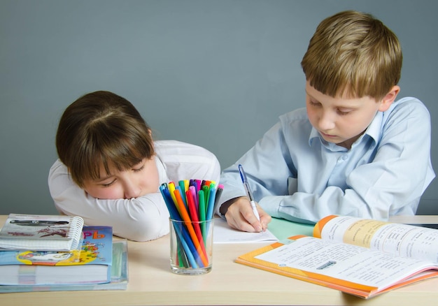 Un niño y una niña estudiantes en el aula en el escritorio.