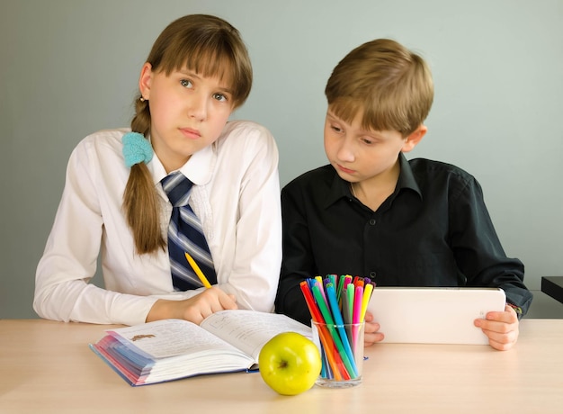 Un niño y una niña estudiantes en el aula en el escritorio.