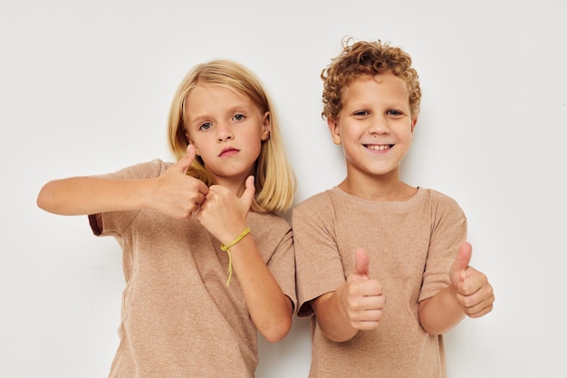 Niño y niña gesticulan con las manos juntas infancia inalterada