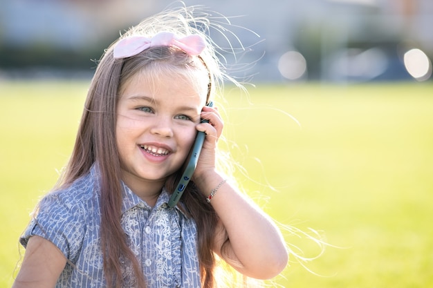 niño niña hablando por teléfono móvil sonriendo