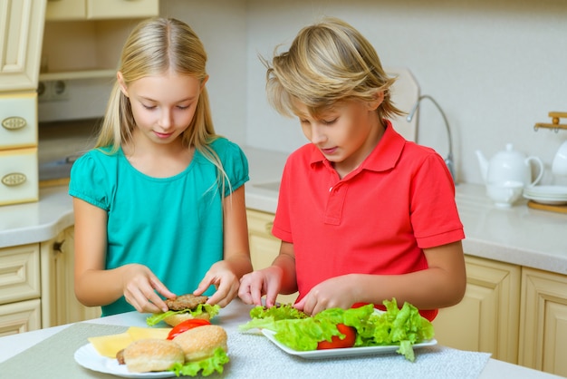 Niño y niña haciendo hamburguesas caseras