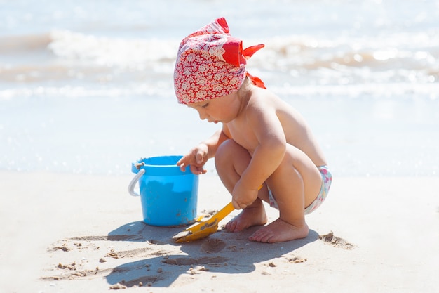 Niño niña juega en una playa.