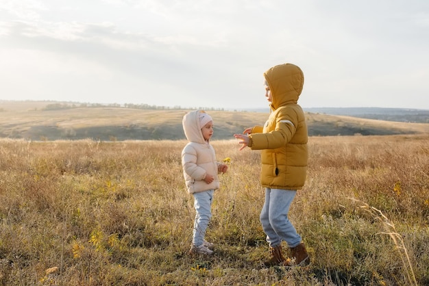 Un niño y una niña juegan juntos en el campo. Regocíjense y rían juntos.