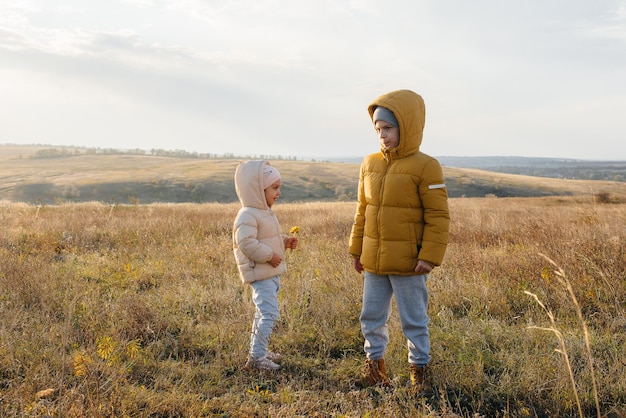 Un niño y una niña juegan juntos en el campo. Regocíjense y rían juntos.