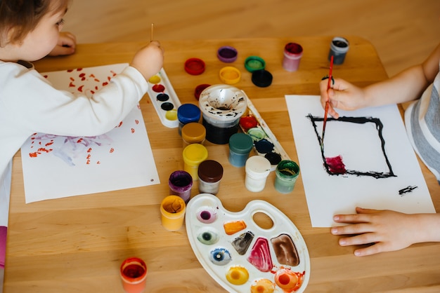 Un niño y una niña juegan juntos y pintan. Recreación y entretenimiento. Quédate en casa.