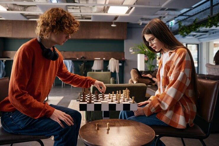 Foto niño y niña jugando al ajedrez en un estudio moderno