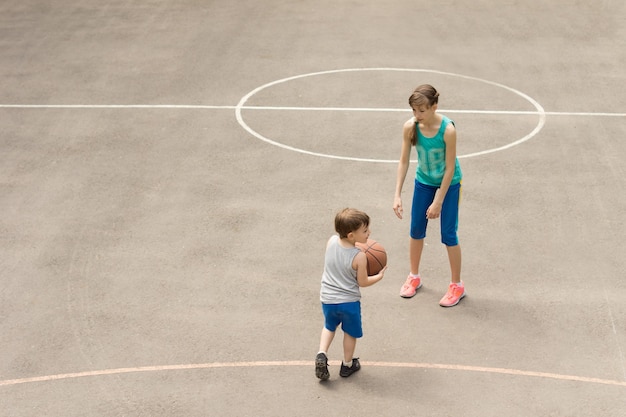 Niño y niña, jugar al básquetbol