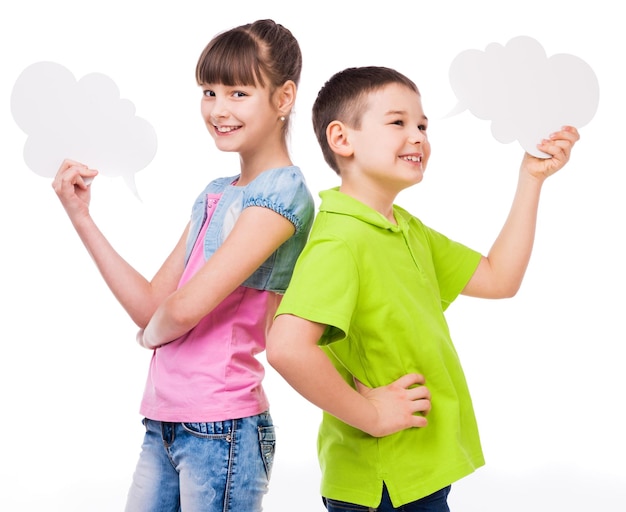 Foto un niño y una niña lindos sosteniendo trozos de papel