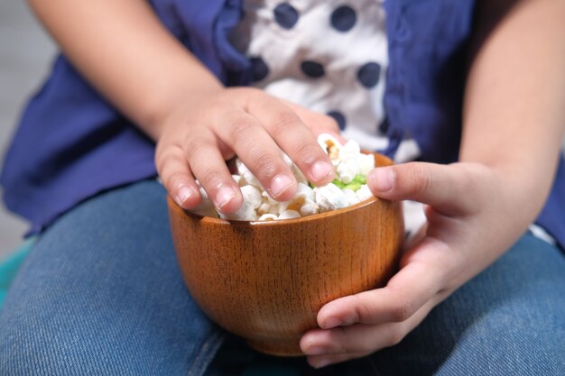 niño niña mano sosteniendo un tazón de palomitas de maíz de colores