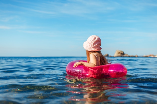 Niño niña en Panamá rosa nadando en el mar con círculo