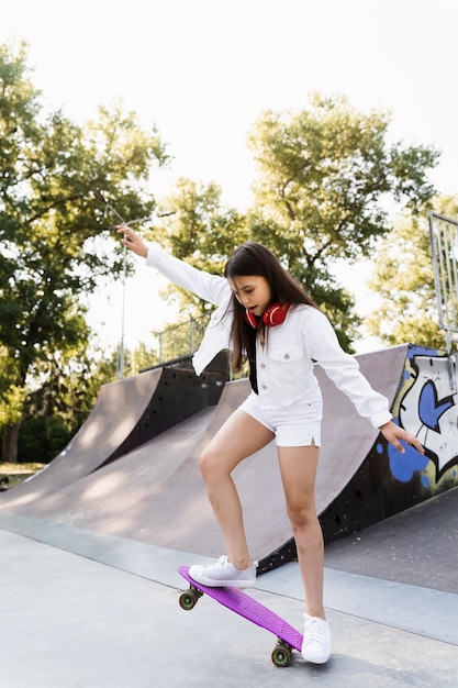 Niño niña paseo en tablero de penny en rampa de deporte de skate al atardecer Equipo deportivo para niños Adolescente activo con pennyboard en parque de juegos de skate