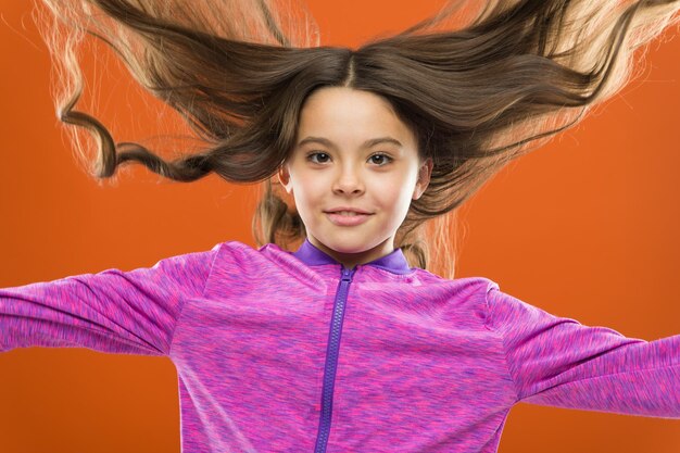 Niño niña pelo largo sano y brillante. A la niña le crece el pelo largo. Enseñar a los niños hábitos saludables para el cuidado del cabello. Concepto de cabello fuerte. La sustancia melanina da pigmento. La persona con marrón tiene mucha más melanina.