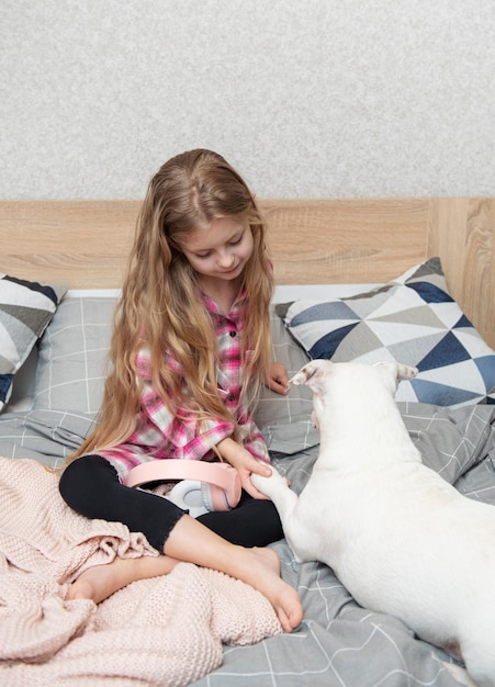 Niño niña y perro La niña le pone los auriculares a su perro