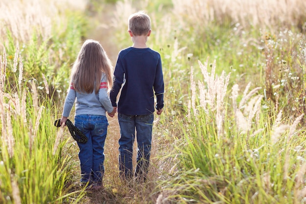 Niño y niña de pie cogidos de la mano