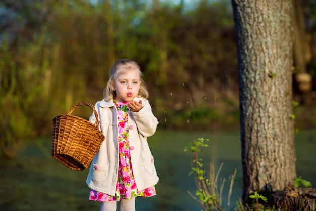 Niño, niña de pueblo con una cesta al atardecer, soplando en la ropa