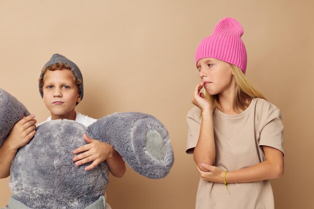 Niño y niña con sombreros con un oso de peluche amistad Estilo de vida inalterado