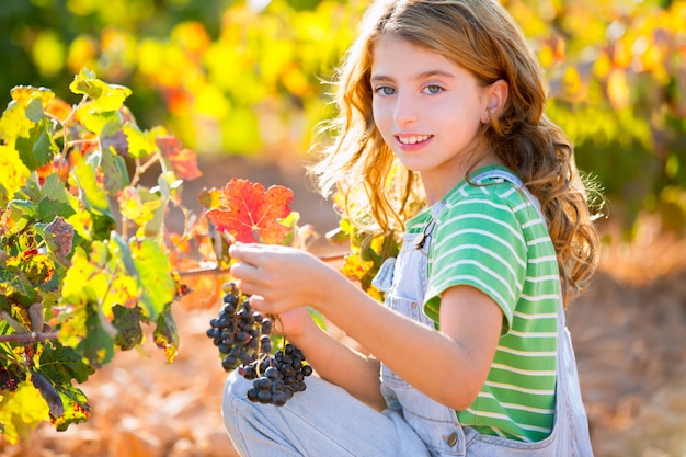 Niño niña sonriente otoño viñedo campo con racimo de uvas