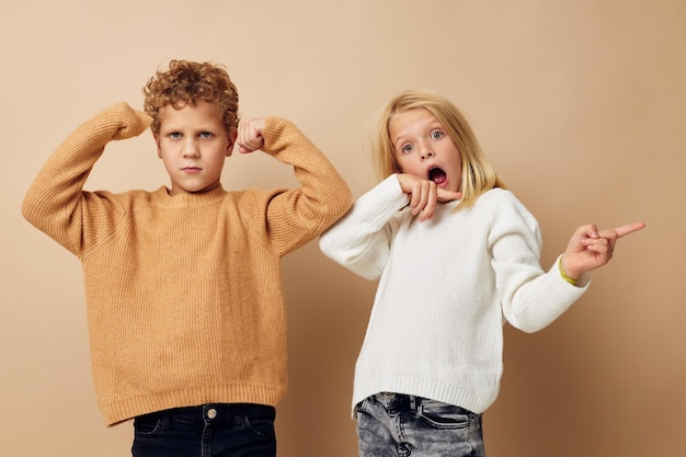 Niño y niña en suéteres juntos diversión infancia inalterada