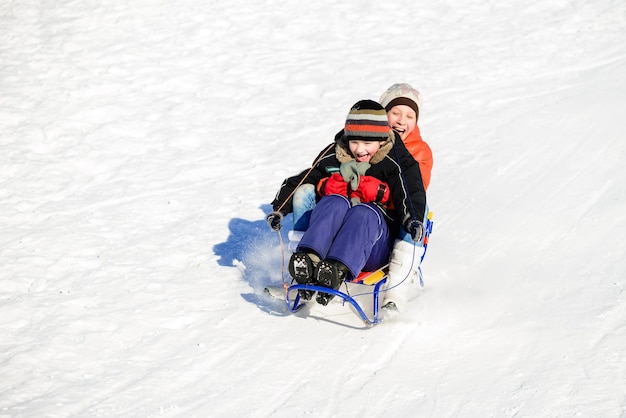 Niño y niña en trineo de invierno