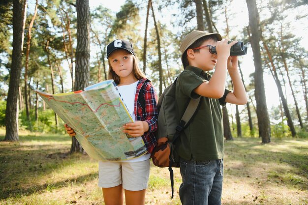 Niño y niña van de excursión por un camino forestal