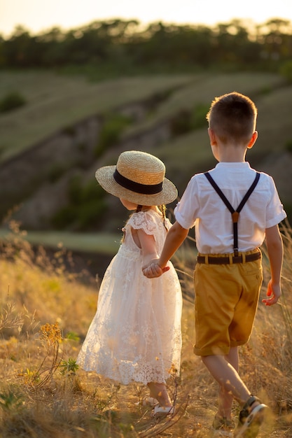 Un niño y una niña van de la mano.