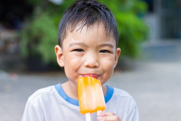 Niño niño asiático comiendo un helado.