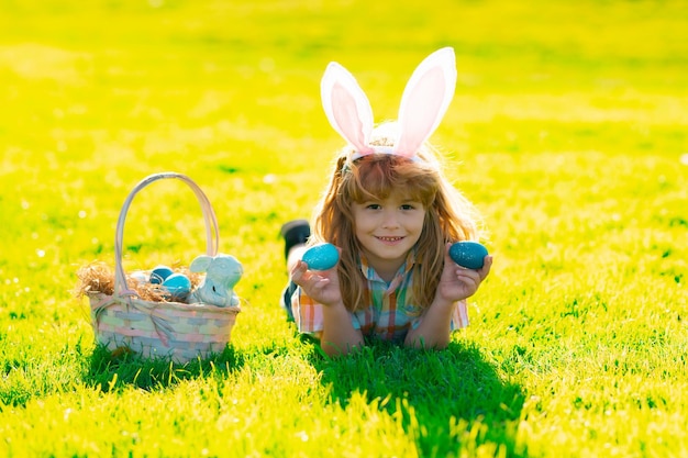 Niño niño cazando huevos de pascua niño niño acostado en la hierba y encontrando huevos de pascua niño niño con este