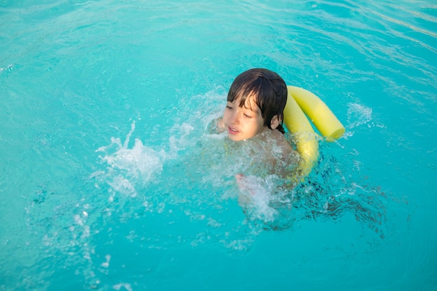 Niño niño chapoteando en la piscina divirtiéndose actividad de ocio