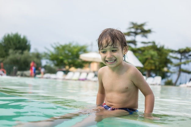 Niño niño chapoteando en la piscina divirtiéndose actividad de ocio