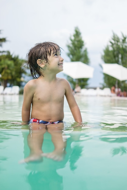 Niño niño chapoteando en la piscina divirtiéndose actividad de ocio