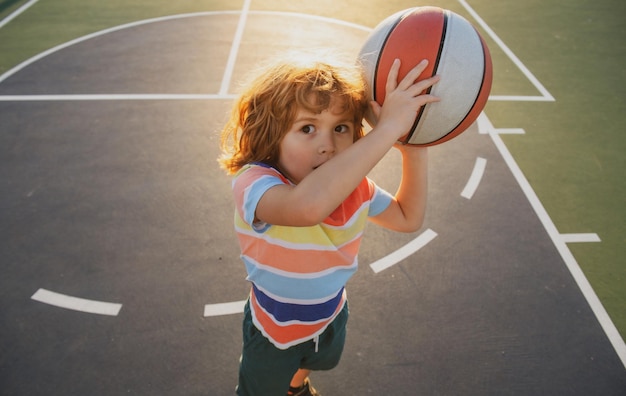 Niño niño concentrado en jugar baloncesto para niños