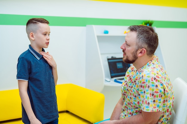 Niño niño contando síntomas en la consulta del médico en el hospital.